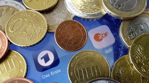 Euromünzen liegen neben den Logos der Apps von ARD und ZDF