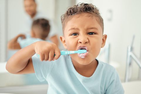 Kind putzt sich die Zähne mit Kinderzahnpasta