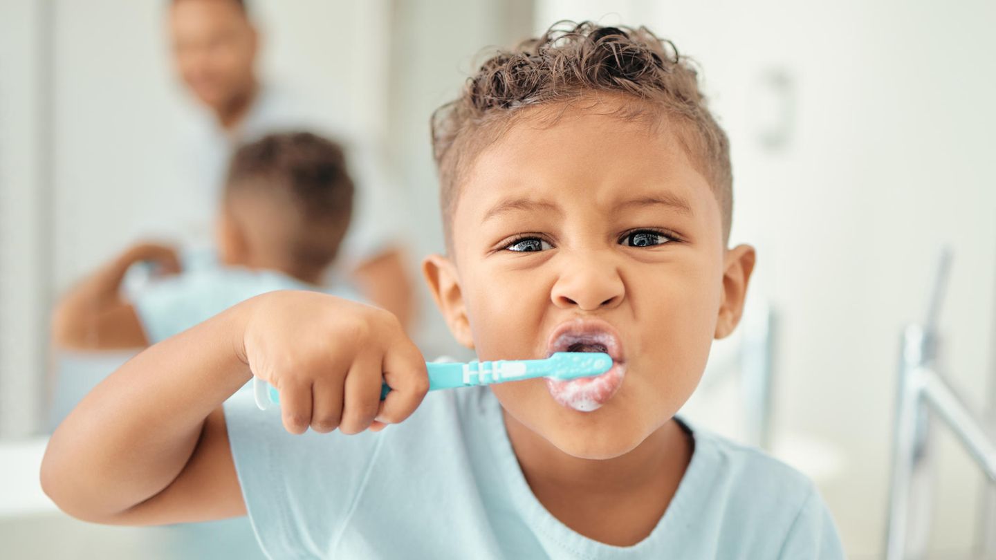 Kind putzt sich die Zähne mit Kinderzahnpasta