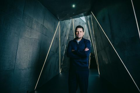 Jan Ulrich steht in einem dunklen Tunnel mit grafischen Linien