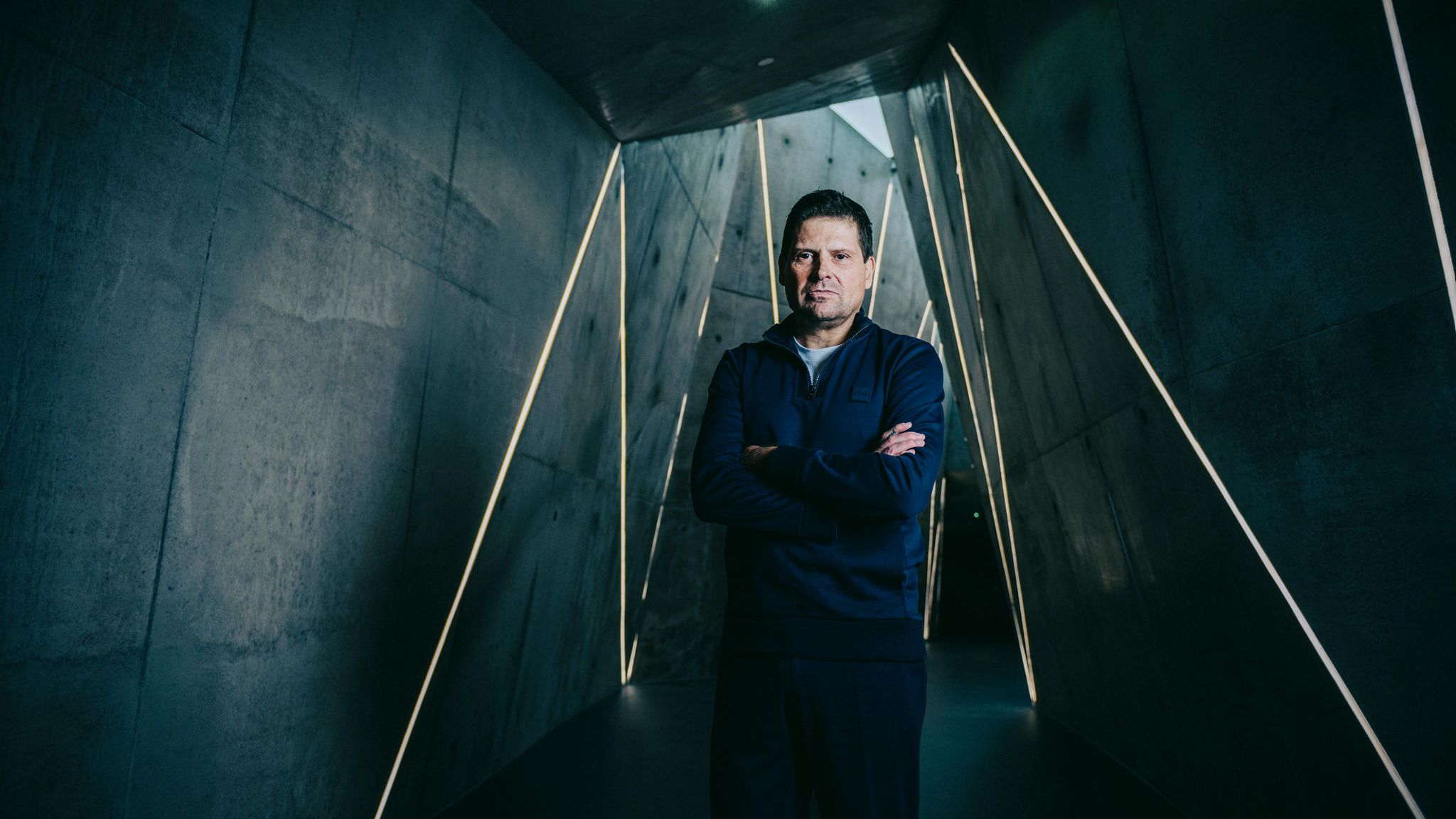Jan Ulrich steht in einem dunklen Tunnel mit grafischen Linien