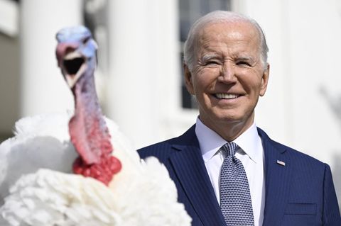Ein Truthahn mit geöffnetem Schnabel sitzt auf einem Podest vor US-Präsident Joe Biden und dem Weißen Haus