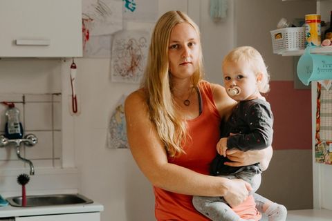 Heike Beddig mit ihrer Tochter auf dem Arm in der Küche