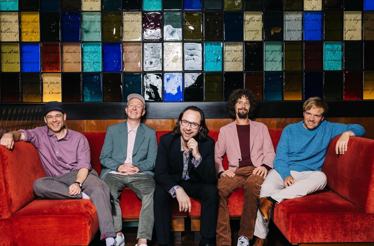 Kai Fischer, Florian Sump, Kim Frank, Andreas Puffpaff und Gunnar Astrup von der Band Echt auf einem roten Sofa