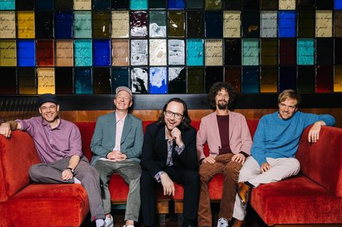 Kai Fischer, Florian Sump, Kim Frank, Andreas Puffpaff und Gunnar Astrup von der Band Echt auf einem roten Sofa