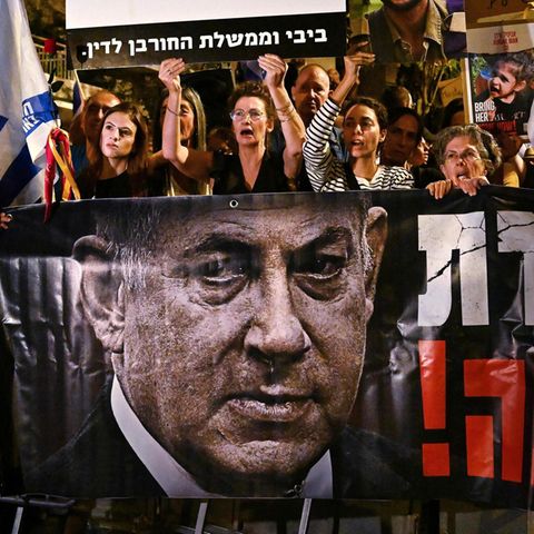 Protestierende mit einem großen Banner fordern Netanyahus Rücktritt