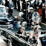 John F. Kennedy und seine Frau Jacqueline in einer offenen Limousine kurz vor dem Attentat