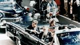 John F. Kennedy und seine Frau Jacqueline in einer offenen Limousine kurz vor dem Attentat