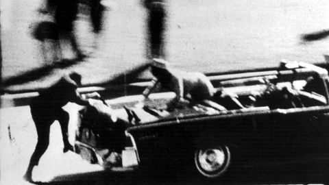 Die Frau des gerade angeschossenen US-Präsidenten John F. Kennedy klettert in Panik auf das Heck der Staatslimousine, sw-Foto