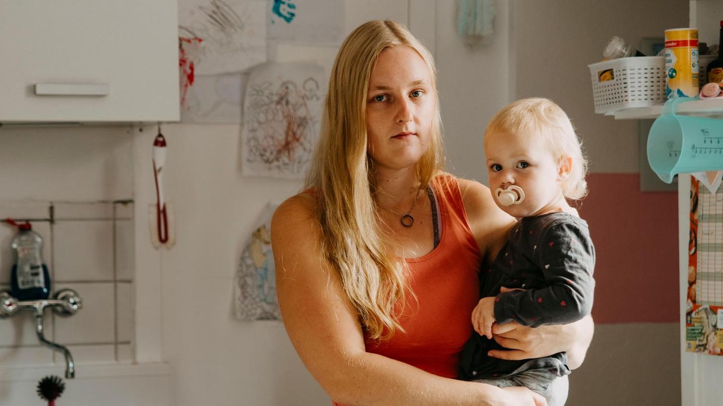 Heike Beddig mit ihrer Tochter auf dem Arm in der Küche