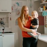 Heike Beddig mit ihrer Tochter auf dem Arm in der Küche