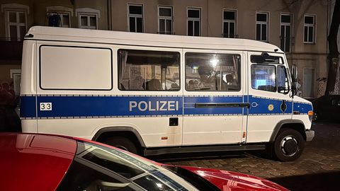 Ein Einsatzfahrzeug der Polizei steht bei einer Razzia in Berlin-Friedrichshain auf der Straße