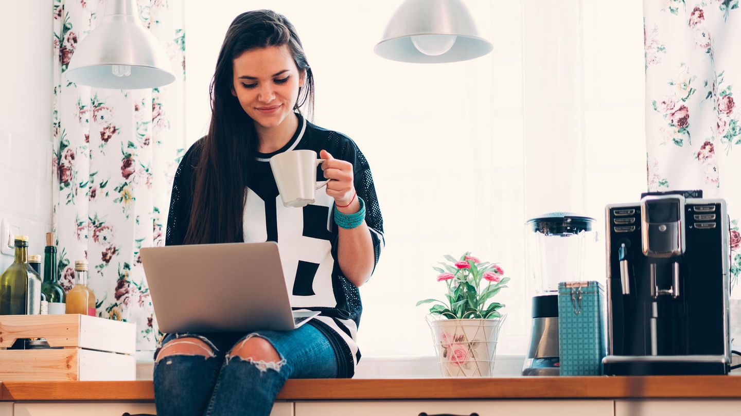 Frau sitzt neben Kaffeemaschine