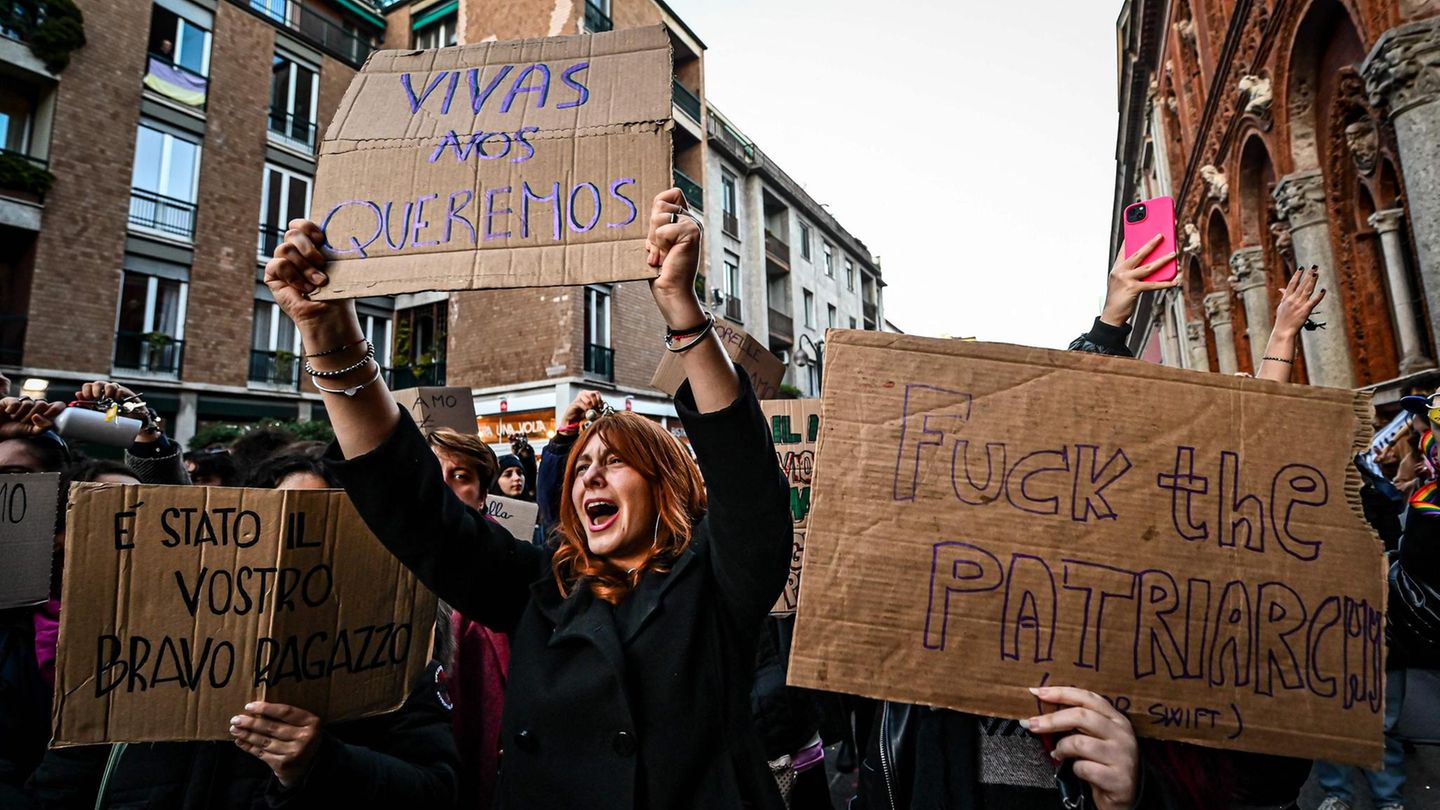 Eine Frau hält ein Protestschild in die Höhe