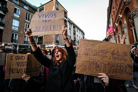 Eine Frau hält ein Protestschild in die Höhe
