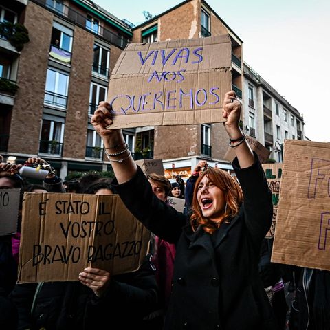 Eine Frau hält ein Protestschild in die Höhe