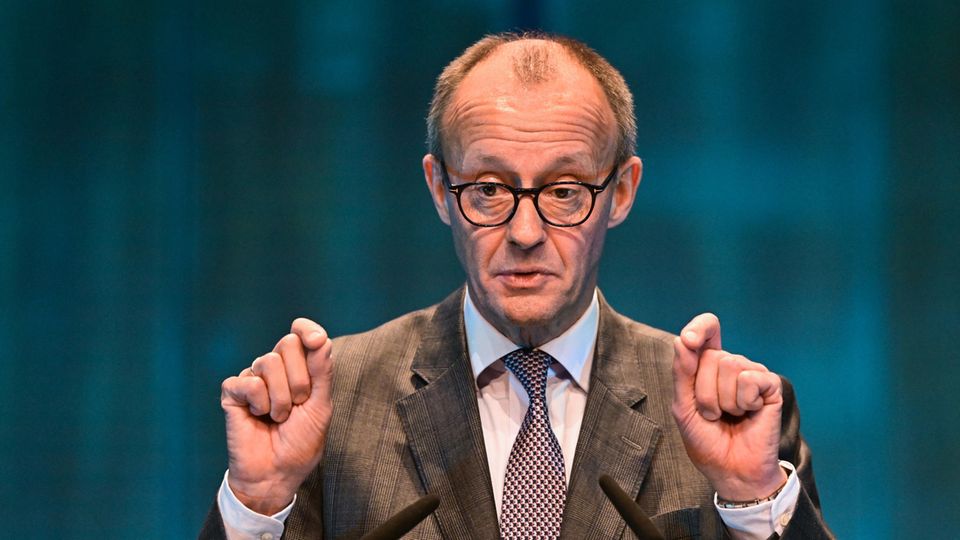 Friedrich Merz steht vor einem Mikrofon und gestikuliert mit beiden Händen während einer Rede