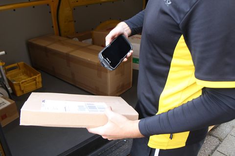 Ein Zusteller liefert ein Paket aus