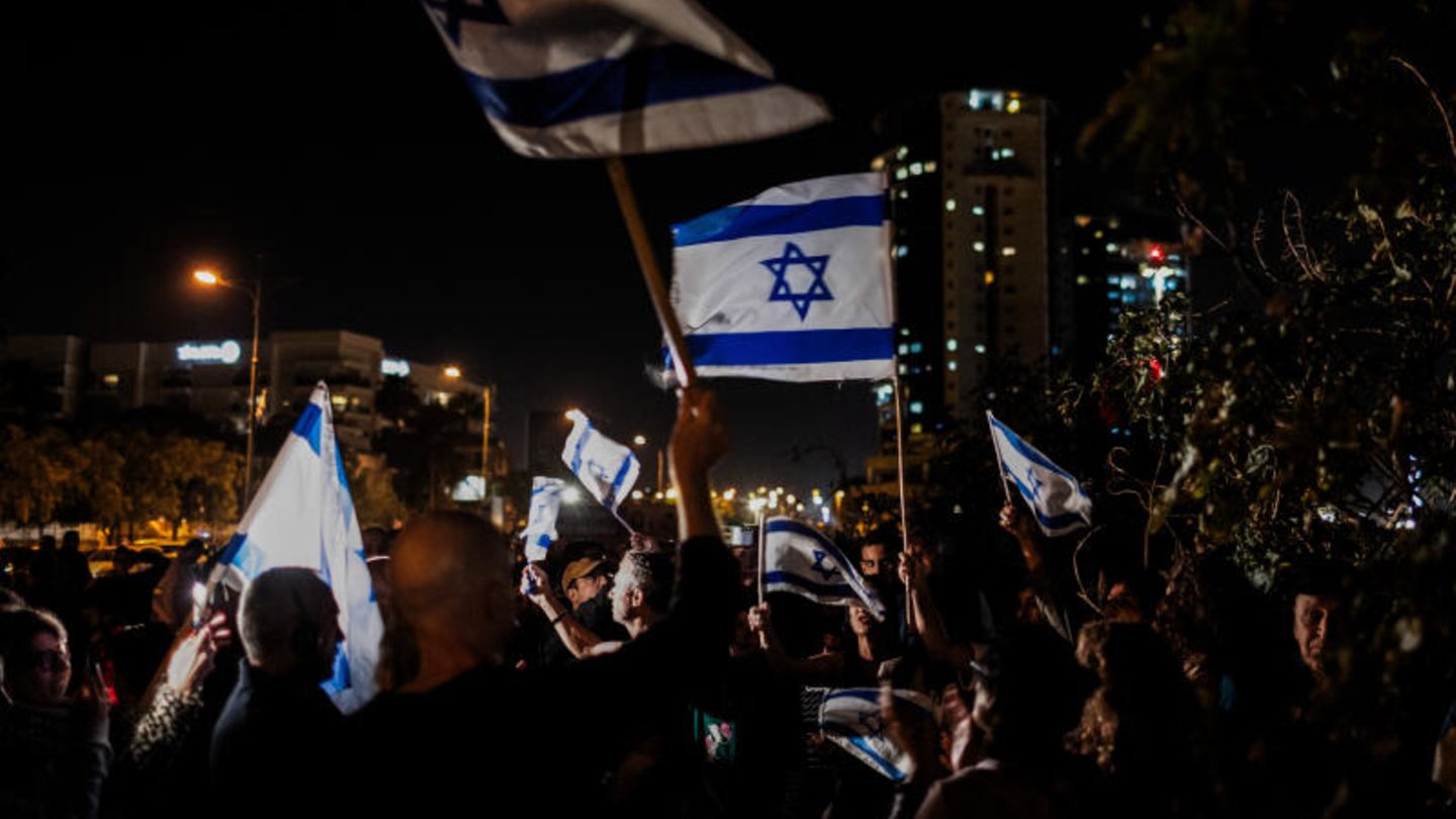 Menschen jubeln mit israelischen Fahnen