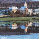 In Riedlingen (Baden-Württemberg) spiegeln sich schneebedeckte Dächer in einer überfluteten Wiese