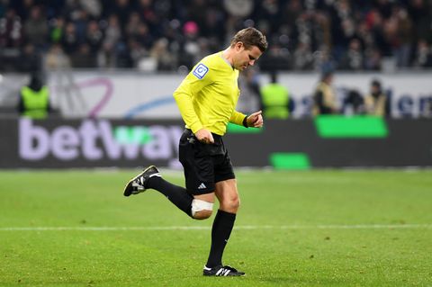 Schiedsrichter Felix Brych läuft mit weißem Tape am linken Knie über den Platz