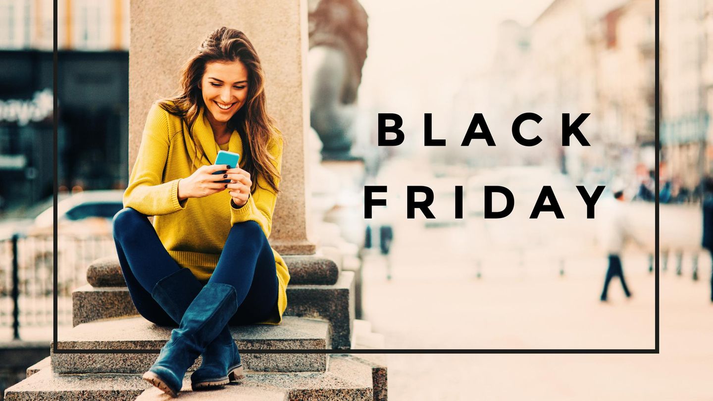 Eine junge Frau, die draußen am Telefon SMS schreibt.