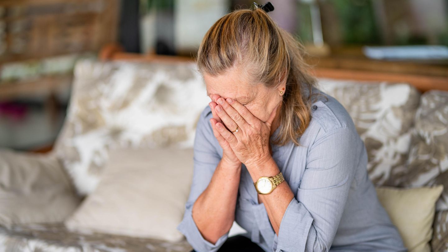Eine Frau bedeckt ihr Gesicht mit den Händen
