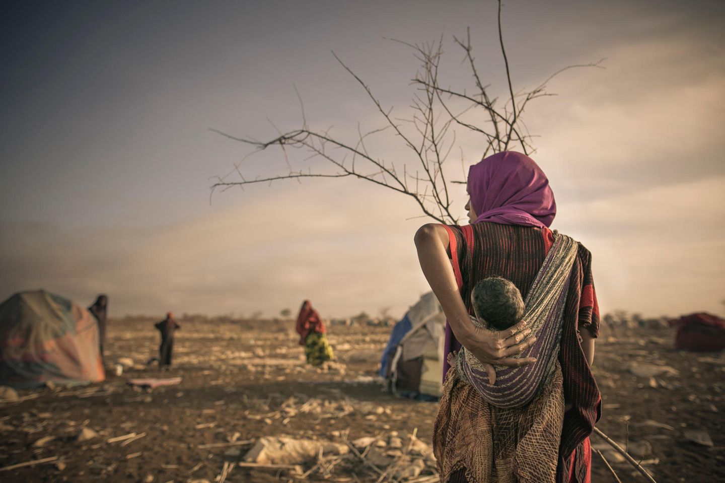 Eine Mutter trägt ihr kleines Kind im Tragetuch