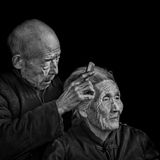 Ein alter Mann kämmt die Haare seiner Frau