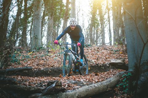 Radmode für Männer: Mountainbiker in einem Waldstück