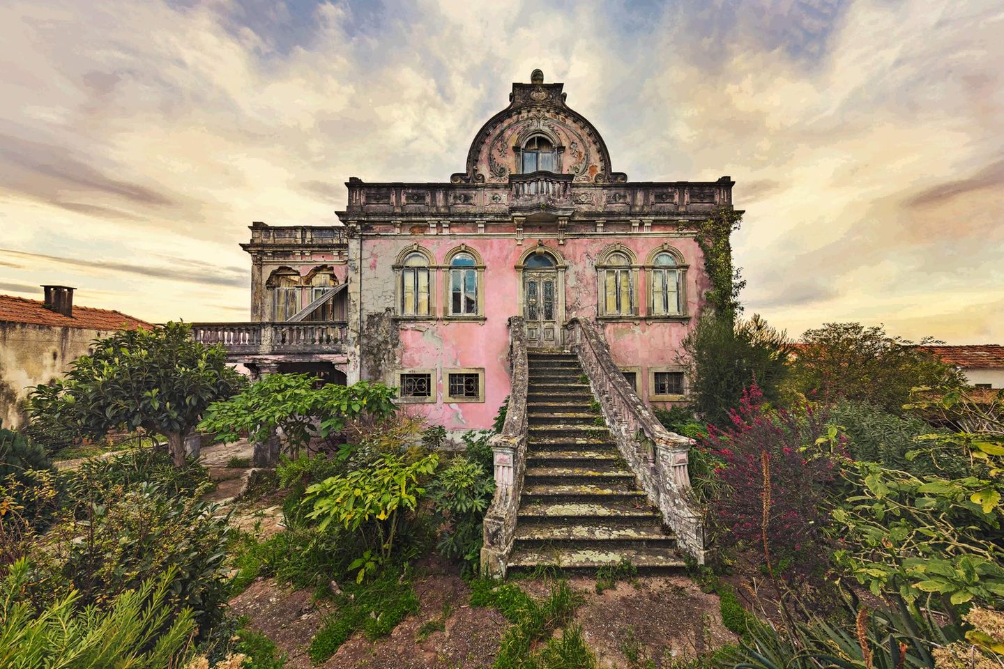 Eine rosafarbene Villa mit eindrucksvoller Treppe