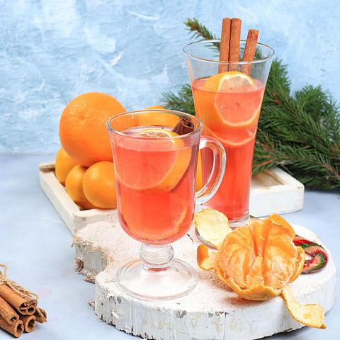 Becher Aperol steht auf dem Tisch eines Straßencafés vor der Kulisse der Berge
