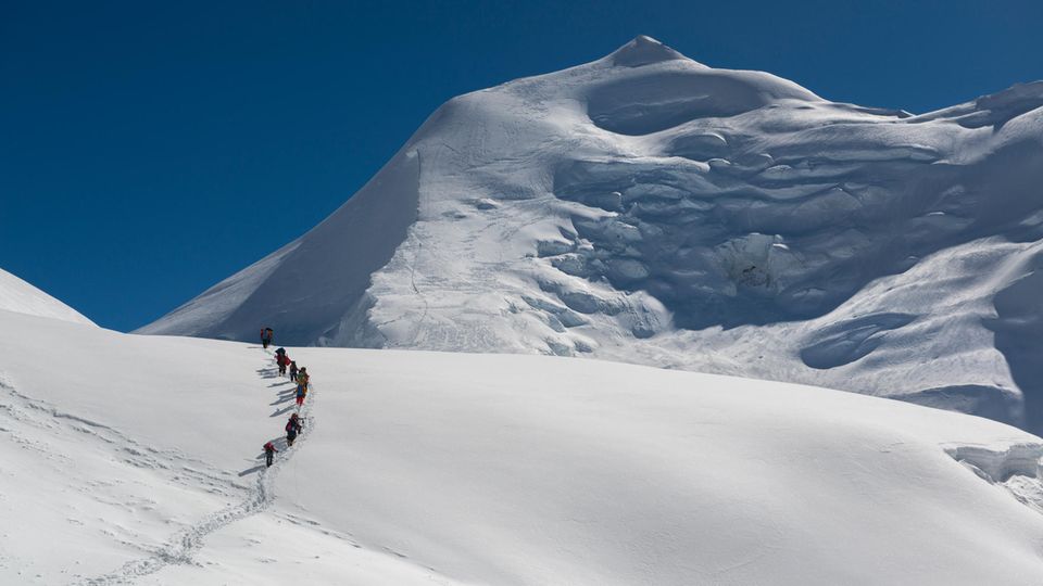 Menschen gehen einen Berg hinauf