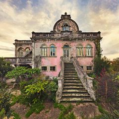 Eine rosafarbene Villa mit eindrucksvoller Treppe