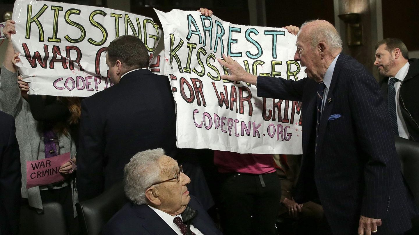 "Arrest Kissinger for War Crimes" steht auf einem Plakat.