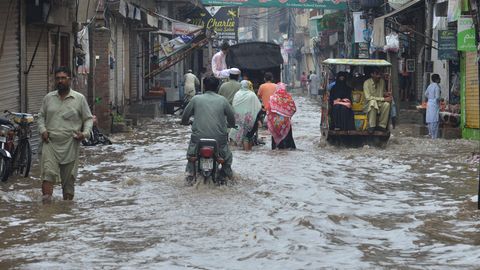Menschen waten durch die Fluten in Pakistan. Klimawandel führt zu Extremwettern