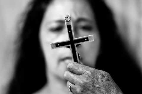 Exorzismus: Ein Kreuz vor dem Gesicht einer Frau