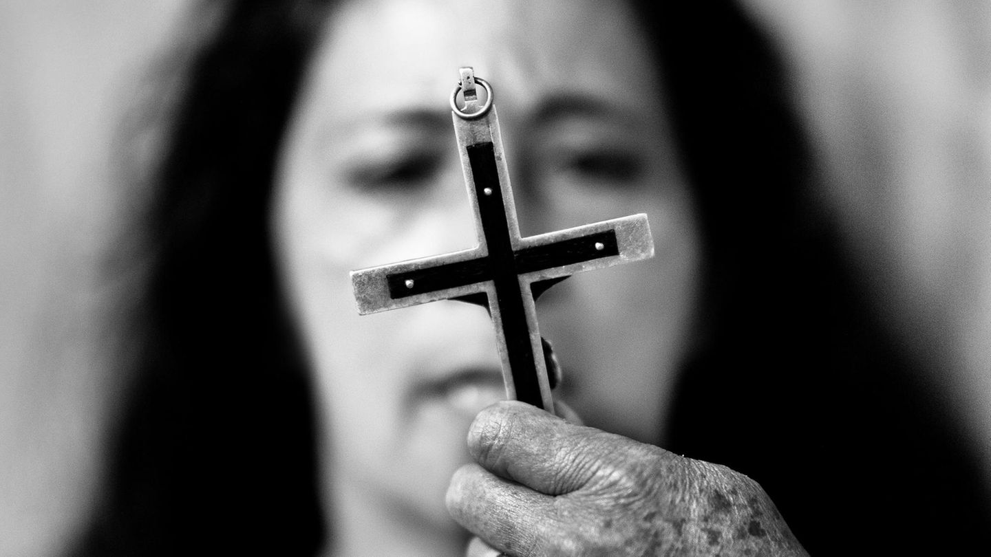 Exorzismus: Ein Kreuz vor dem Gesicht einer Frau
