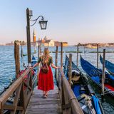 Frau in rotem Rock blickt auf Venedig