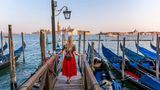 Frau in rotem Rock blickt auf Venedig