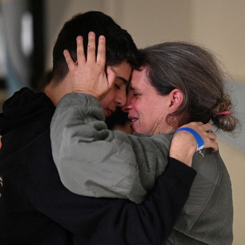 A woman hugs her son in tears