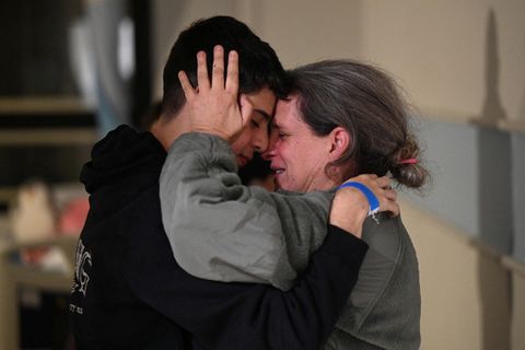 Eine Frau umarmt in Tränen ihren Sohn