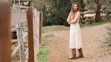 Frau in weißem Kleid und Cowboystiefeln