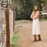 Frau in weißem Kleid und Cowboystiefeln