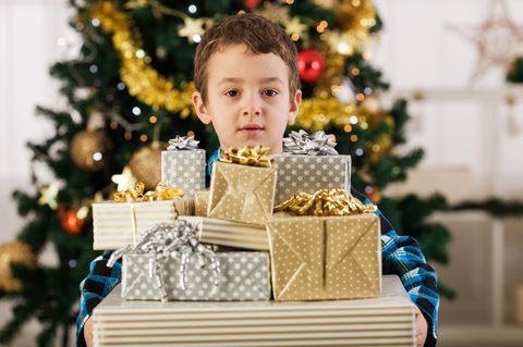 Geschenke zu Weihnachten: Ein Junge mit vielen Geschenken