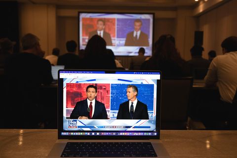 Reporter sehen sich in einem Hotel in Alpharetta, Georgia, die Fernsehdebatte zwischen Ron DeSantis (l.) und Gavin Newsom an