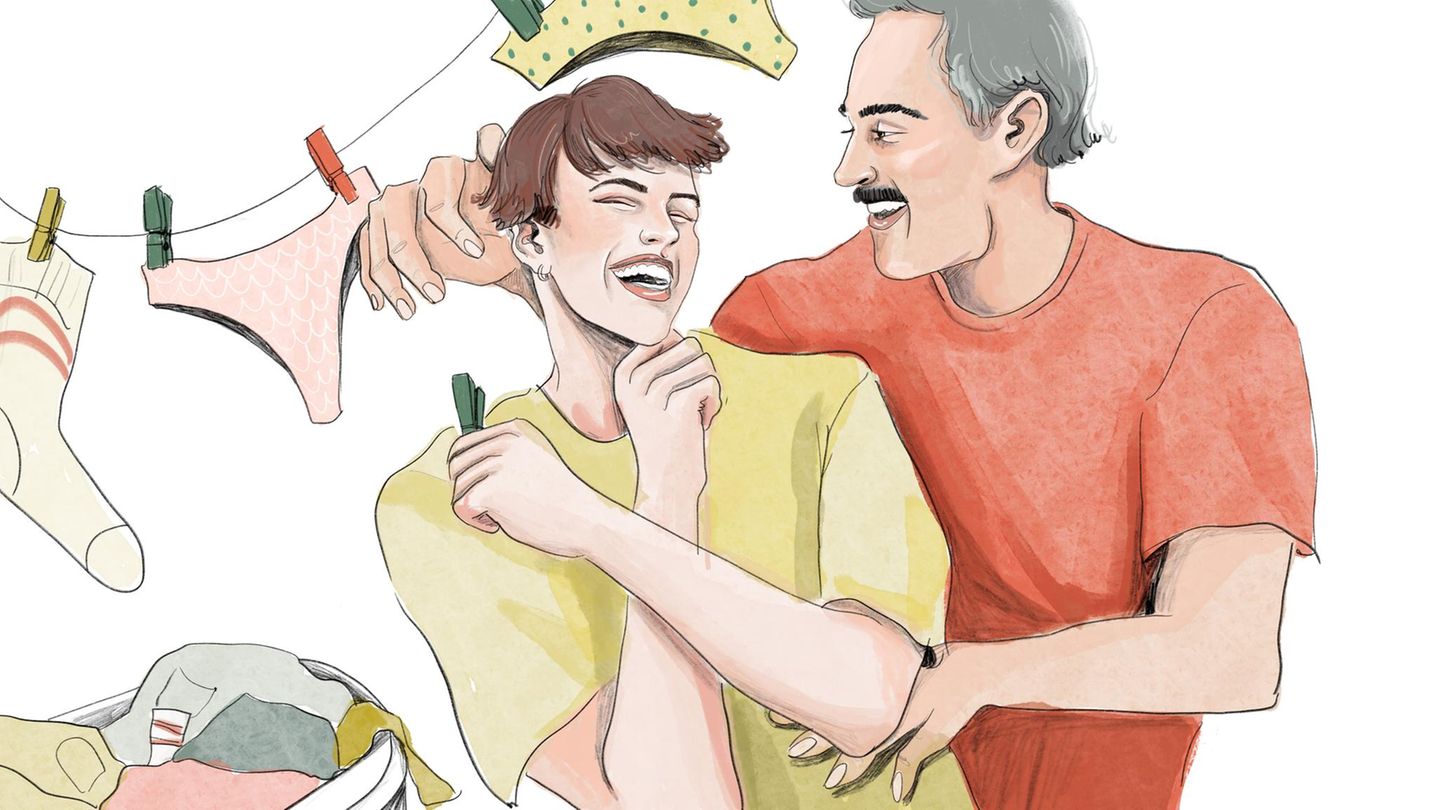 Ein Pärchen lacht und albert beim Wäsche aufhängen