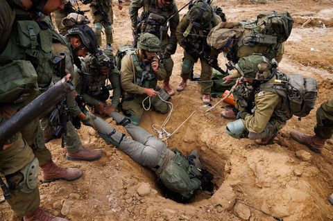 Ein israelischer Soldat kriecht in den Eingang eines Hamas-Tunnels, um Sprengstoff zu setzen