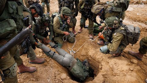Ein israelischer Soldat kriecht in den Eingang eines Hamas-Tunnels, um Sprengstoff zu setzen