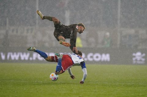 Zweikampf im Schneegestöber: Miro Muheim vom HSV (unten) und St. Paulis Elias Saad fighten um den Ball